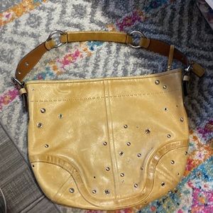 Leather studded and grommet shoulder bag